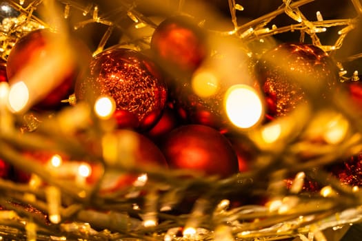 Close up of red Christmas balls baubles. Bokeh garlands. Xmas and holidays concept. Copy space and empty place for text, mock up greeting card.