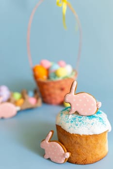 Easter still life with two pink gingerbread in the form of a rabbit on an Easter cake. Vertical