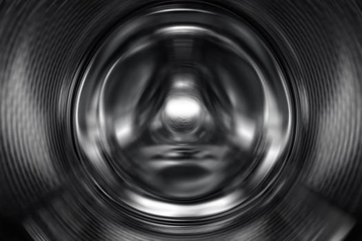 Washing Dryer Machine inside view during work. Drum of the washing machine rotates, view from the inside. Metal drum of a washing machine. Abstract home background. Inside of washing machine.