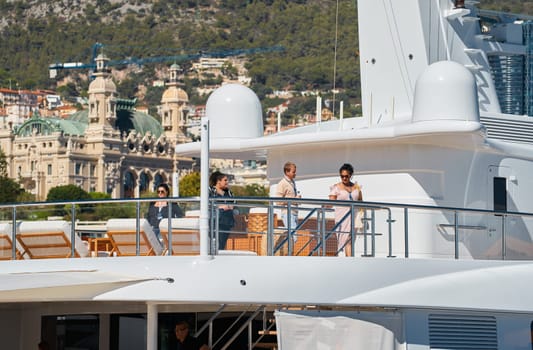 Monaco, Monte Carlo, 28 September 2022 - Invited wealthy clients inspect megayachts at the largest fair exhibition in the world yacht show MYS, port Hercules, yacht brokers, sunny weather. High quality photo