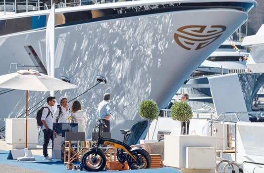 Monaco, Monte Carlo, 28 September 2022 - Invited wealthy clients inspect megayachts at the largest fair exhibition in the world yacht show MYS, port Hercules, yacht brokers, sunny weather. High quality photo