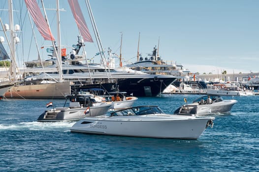 Monaco, Monte Carlo, 28 September 2022 - a motor boat with guests of yacht brokers departs from the shore in the largest fair exhibition in the world yacht show MYS, port Hercules, rich clients, sunny. High quality photo