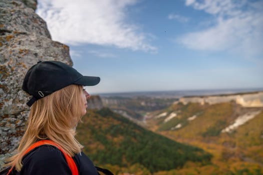 woman backpack on mountain peak looking in beautiful mountain valley in autumn. Landscape with sporty young woman, blu sky in fall. Hiking. Nature.