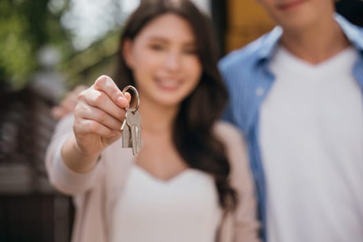 A successful home relocation is captured as a couple displays keys while carrying a mattress. Their happiness echoes the joy of moving in real estate. Moving Day Concept