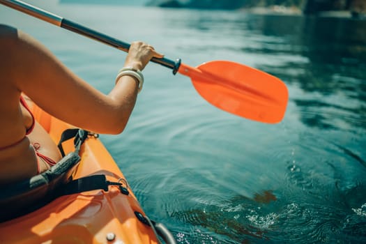 Kayak paddle sea vacation. Person paddles with orange paddle oar on kayak in sea. Leisure active lifestyle recreation activity rest tourism travel.