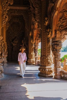 Asian women visit The Sanctuary of Truth wooden temple in Pattaya Thailand, sculpture of Sanctuary of Truth temple.