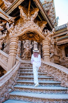 Asian Thai women visit The Sanctuary of Truth wooden temple in Pattaya Thailand, sculpture of Sanctuary of Truth temple.