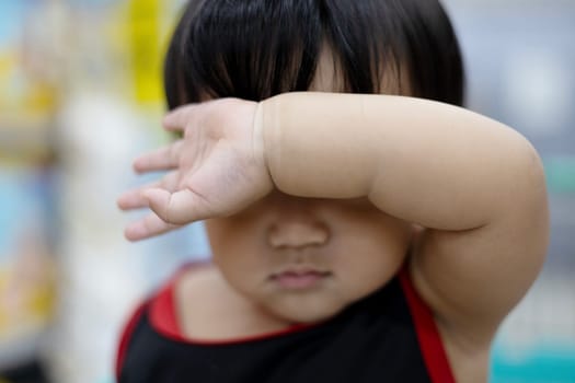 Cute boy  holding his right arm on the front as protecting from sun. Boy Holding His Arm In Front Of His Face.