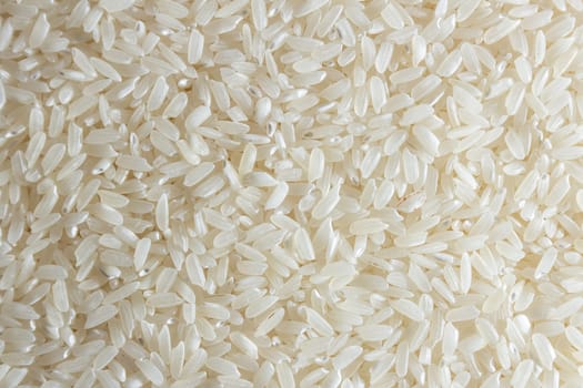 Dry Uncooked White Rice Background - Top View, Flat Lay. Scattered Raw Long Grain Rice. Asian Cuisine and Culture. Healthy Eating Ingredients. Diet Food