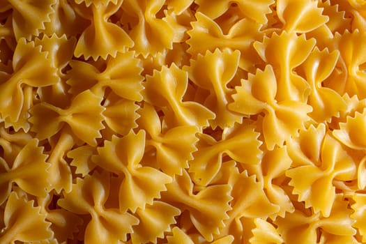 Uncooked Farfalle Pasta: A Culinary Canvas of Bow-Tie Macaroni, Creating a Lively and Textured Background for Gourmet Cooking. Dry Pasta. Raw Macaroni - Top View, Flat Lay