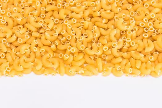 Uncooked Chifferi Rigati Pasta Scattered on White Table. Fat and Unhealthy Food. Classic Dry Macaroni. Italian Culture and Cuisine. Raw Pasta