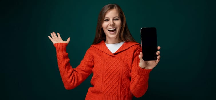 Cheerful 30 year old woman with brown hair showing off new smartphone with mockup.