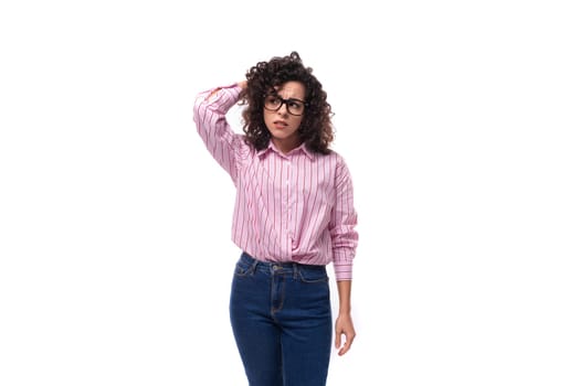 young charming caucasian woman with curly hair dressed in a loose-fitting striped shirt wears glasses.