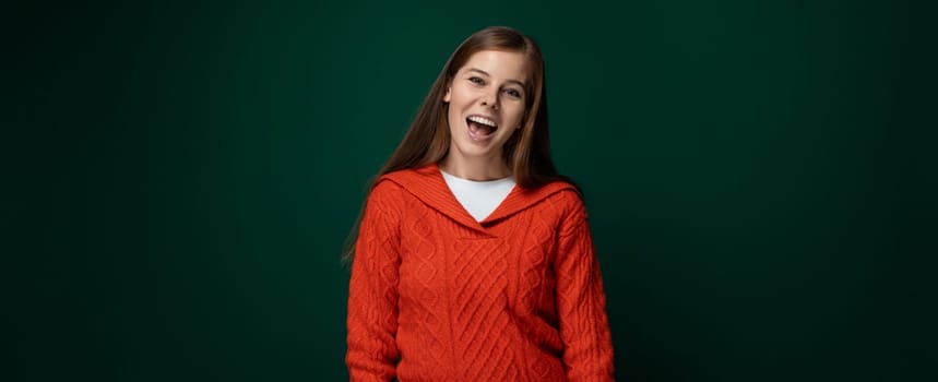 Well-groomed 30 year old woman with brown hair wears a red knitted sweater on a green background.