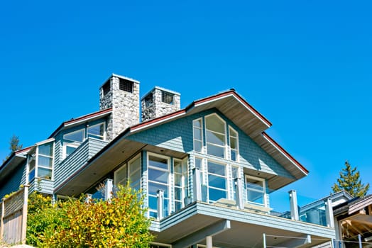 Top of residential house with patio on blue sky background.
