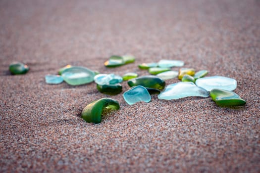 Mediterranean sea beach and glass stones photo. Glass stones from broken bottles polished by the sea. Front view photography with blurred background. High quality picture for wallpaper, travel blog