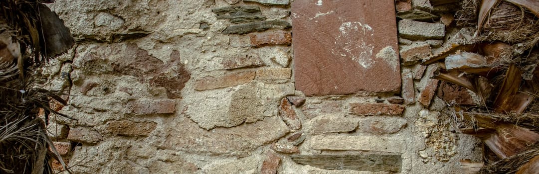 Close up old gray brick texture wall concept photo. Medieval architecture, backyard with palm trees. District of European town, Barcelona. High quality picture for wallpaper, travel blog.