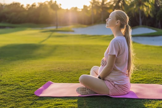 Energetic pregnant woman takes her workout outdoors, using an exercise mat for a refreshing and health-conscious outdoor exercise session.