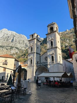 Ancient bell towers of the Cathedral of St. Tryphon in Kotor against the backdrop of the mountains. Montenegro. High quality photo