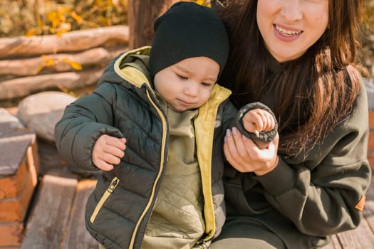 happy loving young mother kisses her toddler son on the walk.