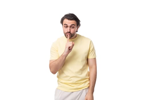 portrait of a pensive stylish brunette european man with a beard and mustache dressed in a summer t-shirt.