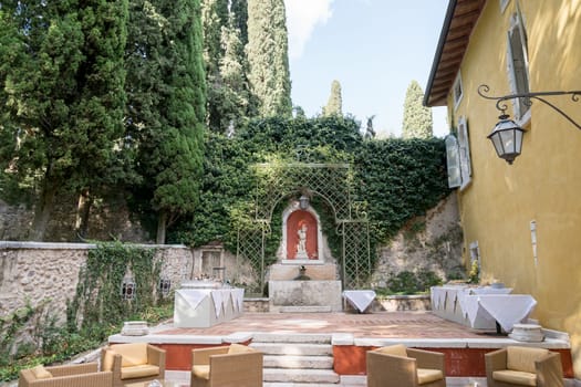 Set buffet tables near armchairs in the courtyard of an ancient villa. High quality photo