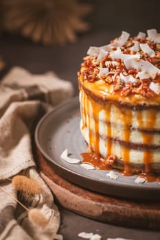 Delicious caramel cake with small pieces of pecan nuts and coconut shavings.