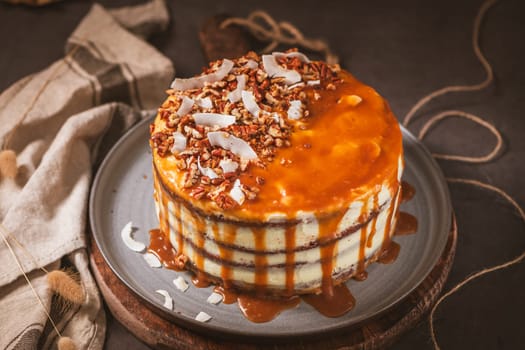 Delicious caramel cake with small pieces of pecan nuts and coconut shavings.