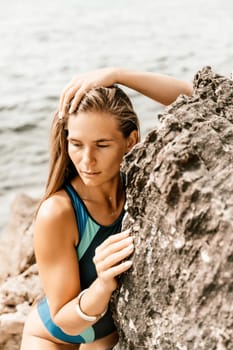 Woman beach vacation photo. A happy tourist in a blue bikini enjoying the scenic view of the sea and volcanic mountains while taking pictures to capture the memories of her travel adventure