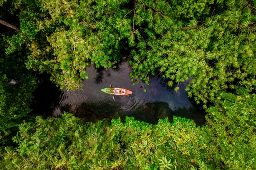 couple in a kayak in the jungle of Krabi Thailand, men and women in a kayak in a tropical jungle in Krabi mangrove forest.