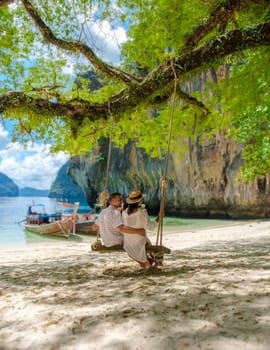 Koh Lao Lading Island near Koh Hong Krabi Thailand, a couple of European men and an Asian woman on the beach. Couple on a boat trip in Krabi Thailand