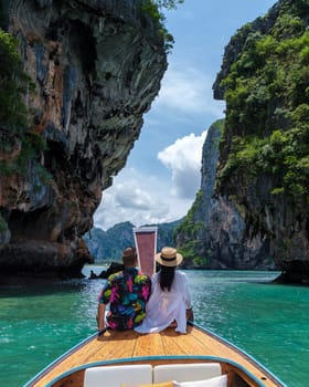 Luxury Longtail boat in Krabi Thailand, couple man and woman on a trip to the tropical island 4 Island in Krabi Thailand. Asian woman and European man mid age on vacation in Thailand.