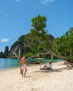 Koh Phakbia Island is near Koh Hong Krabi, a beautiful white sandy beach in Krabi Thailand. Young Asian women and European men on the beach during a vacation in Thailand.