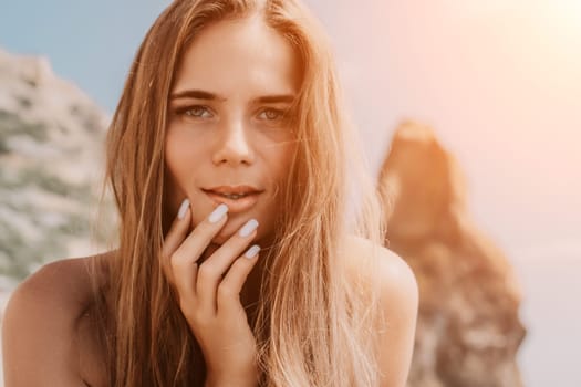 Woman travel sea. Young Happy woman in a long red dress posing on a beach near the sea on background of volcanic rocks, like in Iceland, sharing travel adventure journey