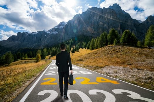 2024 New Year journey and future vision concept . Businessman traveling on highway road leading forward to happy new year celebration in beginning of 2024 for bliss and successful start .