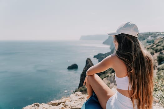 Woman meditating in yoga pose silhouette at the ocean, beach and rock mountains. Motivation and inspirational fit and exercising. Healthy lifestyle outdoors in nature, fitness concept.