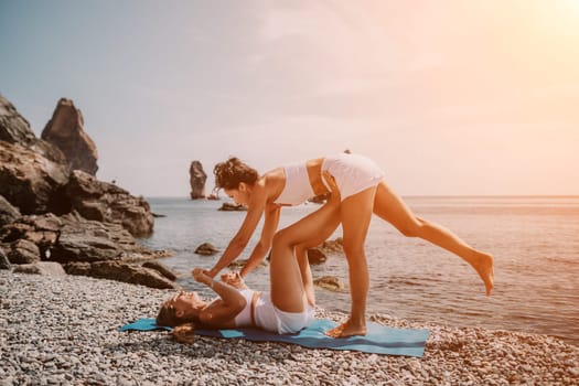 Woman sea yoga. Back view of free calm happy satisfied woman with long hair standing on top rock with yoga position against of sky by the sea. Healthy lifestyle outdoors in nature, fitness concept.