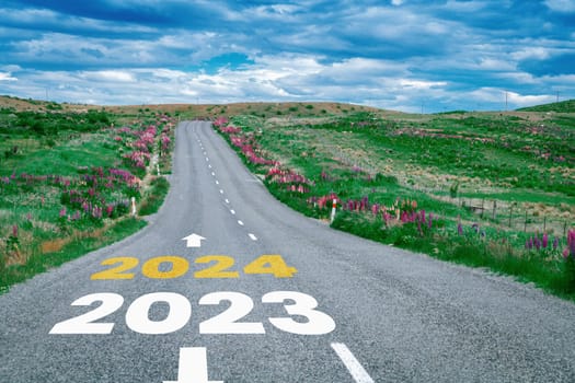 2024 New Year road trip travel and future vision concept . Nature landscape with highway road leading forward to happy new year celebration in the beginning of 2024 for bliss and successful start .