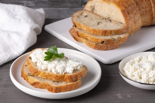 Bread with curd cheese on wooden board.