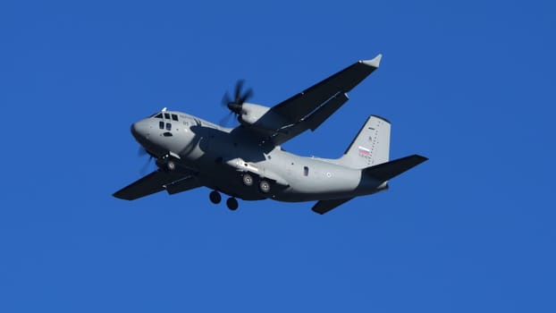 Cerklje ob Krki Slovenia December 20 2023: Military Cargo Airplane in Flight at Low Speed with Landing Gear Down over Blue Sky. Leonardo C-27J Spartan Martin Krpan of Slovenian Air Force. Copy Space.