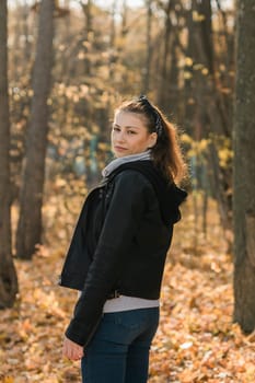 Outdoor atmospheric lifestyle portrait of young beautiful young woman copy space. Warm autumn fall season. Millennial generation and youth.