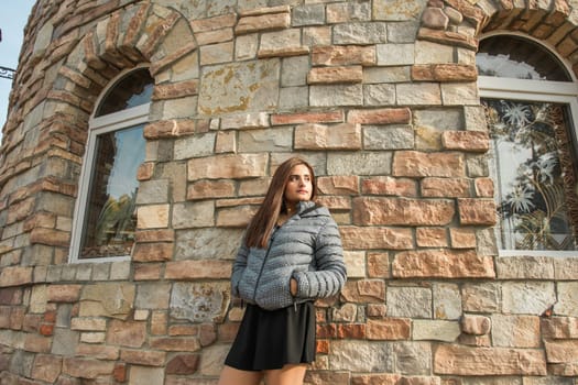 Portrait of diversity young beautiful confident Indian Asian woman in fall season brick building background. Happy and natural smiling female. Generation z and gen z youth