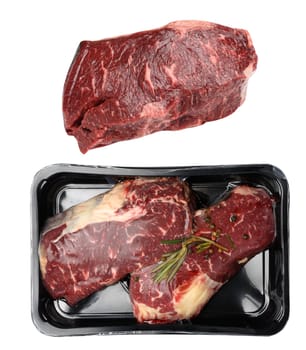 Two raw beef steaks in a plastic container with spices and vacuumized on a white background, packaging for long-term storage, top view