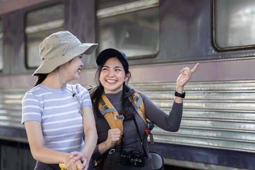 Two female friend talking about trip on their way to train. traveling concept.