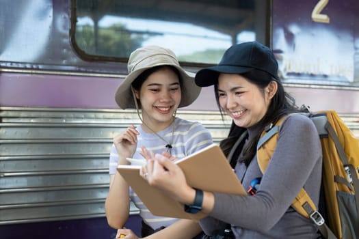 Two female friend talking about trip on their way to train. traveling concept.