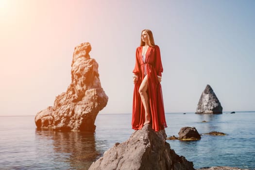 Woman travel sea. Happy tourist taking picture outdoors for memories. Woman traveler looks at the edge of the cliff on the sea bay of mountains, sharing travel adventure journey.