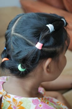 Beautiful ribbon is tied on a child hair .