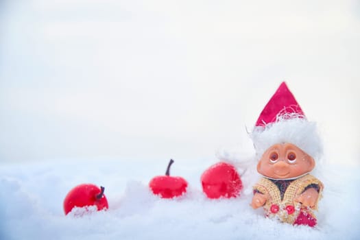Cute little funny dwarf in the snow in the landscape in winter. Wizard on a snowy background. Christmas and New Year