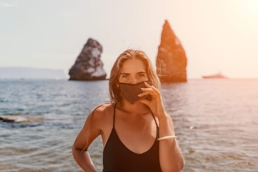 Woman travel sea. Young Happy woman in a long red dress posing on a beach near the sea on background of volcanic rocks, like in Iceland, sharing travel adventure journey