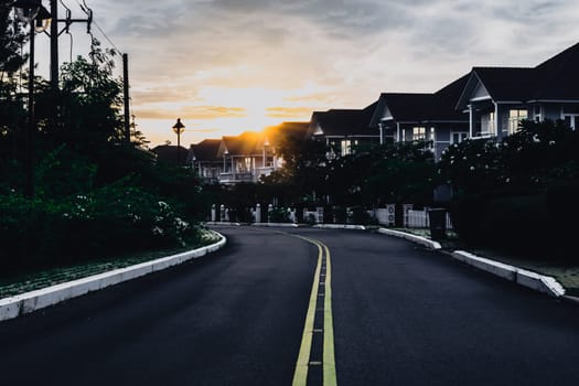 Modern cottages row road sidewalk two story buildings residential villas village New Estate Reflection dawn Sun in windows.